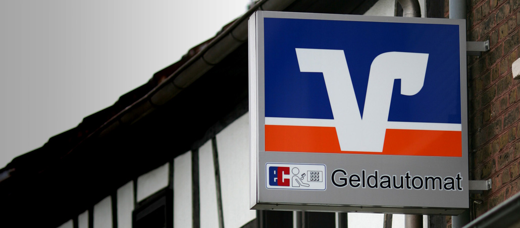 Das Logo der Volks- und Raiffeisenbanken an einem Fachwerkhaus.