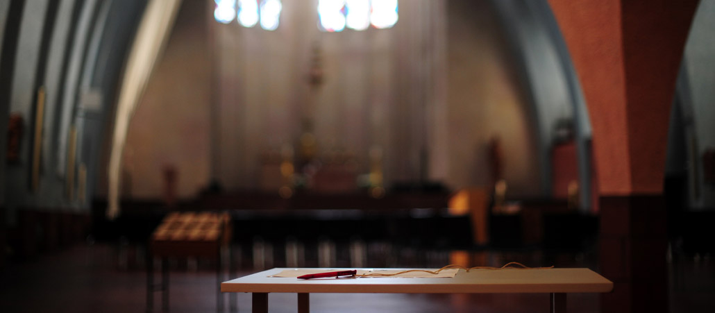 Ein Tisch mit einem Blatt und einem Stift in einer Kirche