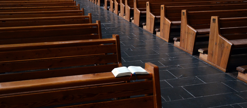 Ein Gotteslob liegt in einer Kirchenbank.