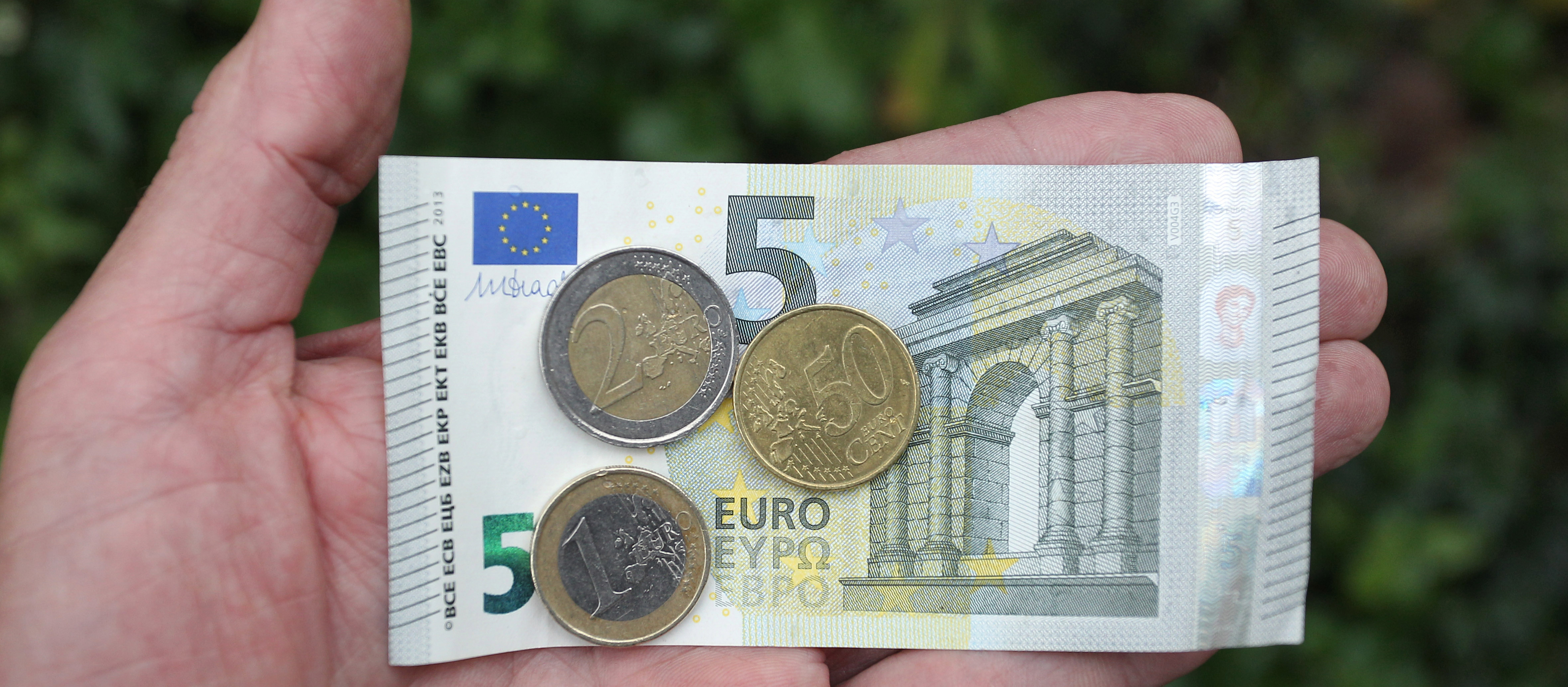 Eine Hand hält am 23.10.2013 in Kaufbeuren (Bayern) acht Euro und fünfzig Cent. Die SPD fordert in den Koalitionsverhandlungen diesen Betrag als allgemeinverbindlichen gesetzlichen Mindestlohn.