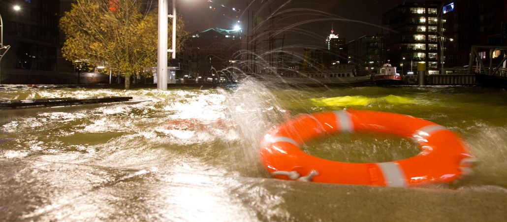 Ein Rettungsring schwimmt durch eine überflutete Straße.