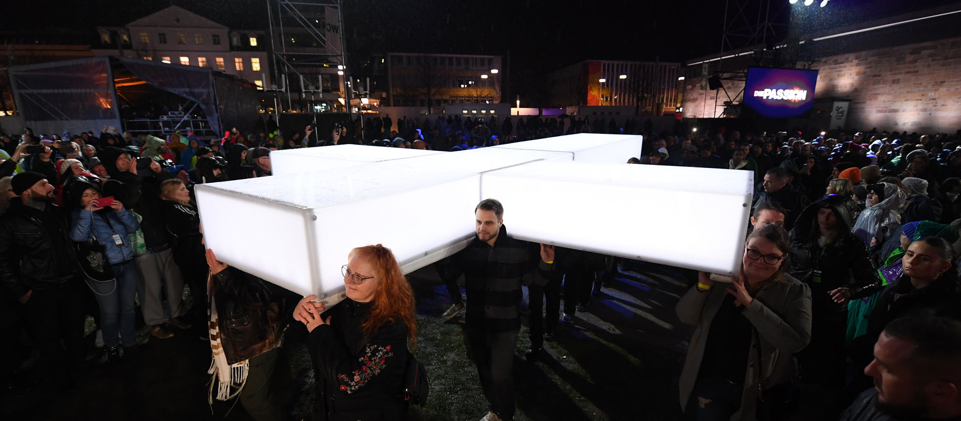 Ein leuchtendes Kreuz wird bei der RTL-Oster-Produktion "Die Passion" auf den Friedrichsplatz getragen.