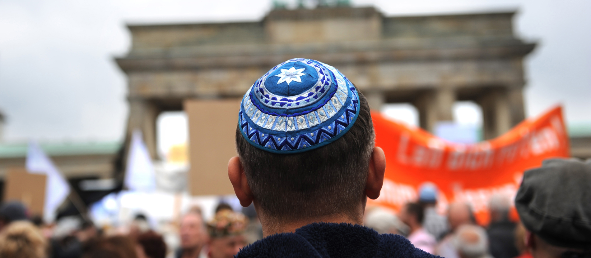 Ein Mann steht mit Kippa vor dem Brandenburger Tor