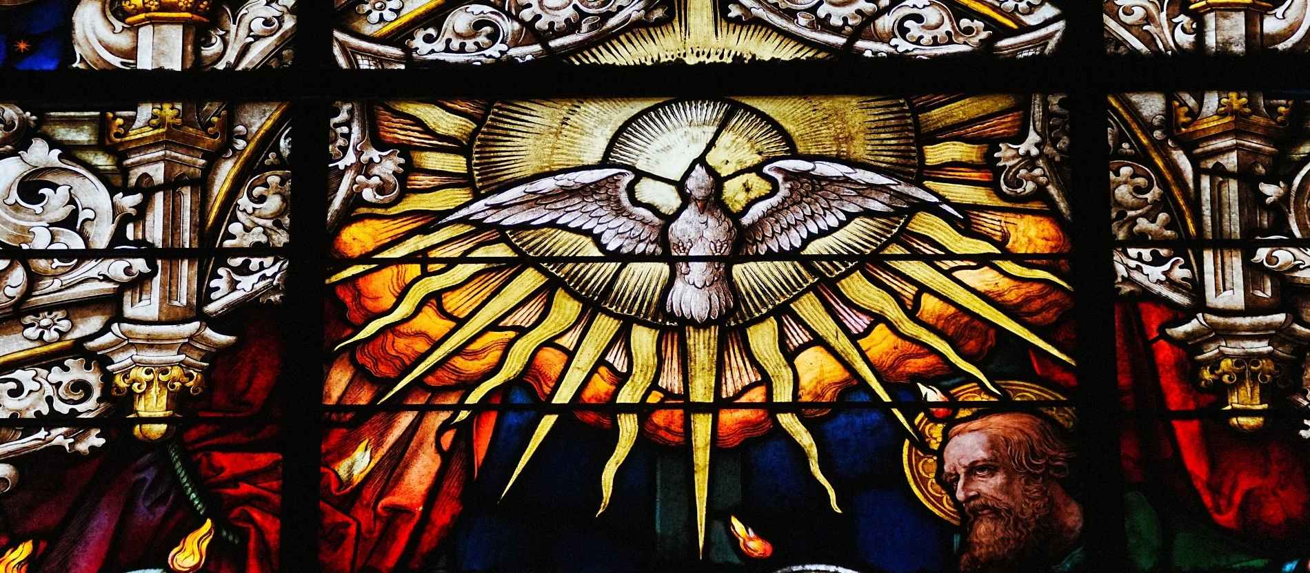 Ein Bleiglasfesnter in der Kathedrale von Sevilla zeigt den Heiligen Geist in Gestalt einer von einem Strahlenkranz umgebenen Taube.