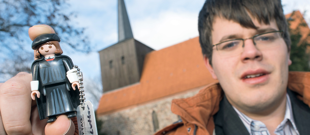 Lars Fischer zeigt eine Playmobil-Figur in Gestalt von Martin Luther