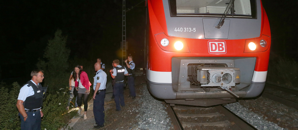 Polizisten stehen am 18.07.2016 in Würzburg (Bayern) neben einem Regionalzug.