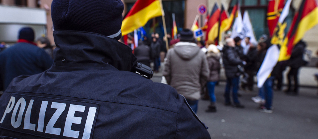 Ein Polizist beobachtet eine rechte Demonstration in der Kölner Innenstadt
