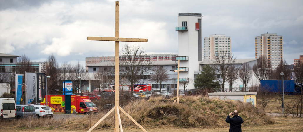 Eine Mann fotografiert am 06.03.2017 in Erfurt (Thüringen) ein großes Holzkreuz.