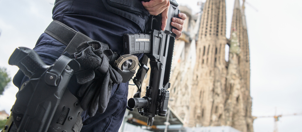 Ein schwer bewaffneter Polizist steht vor der Sagrada Familia in Barcelona.