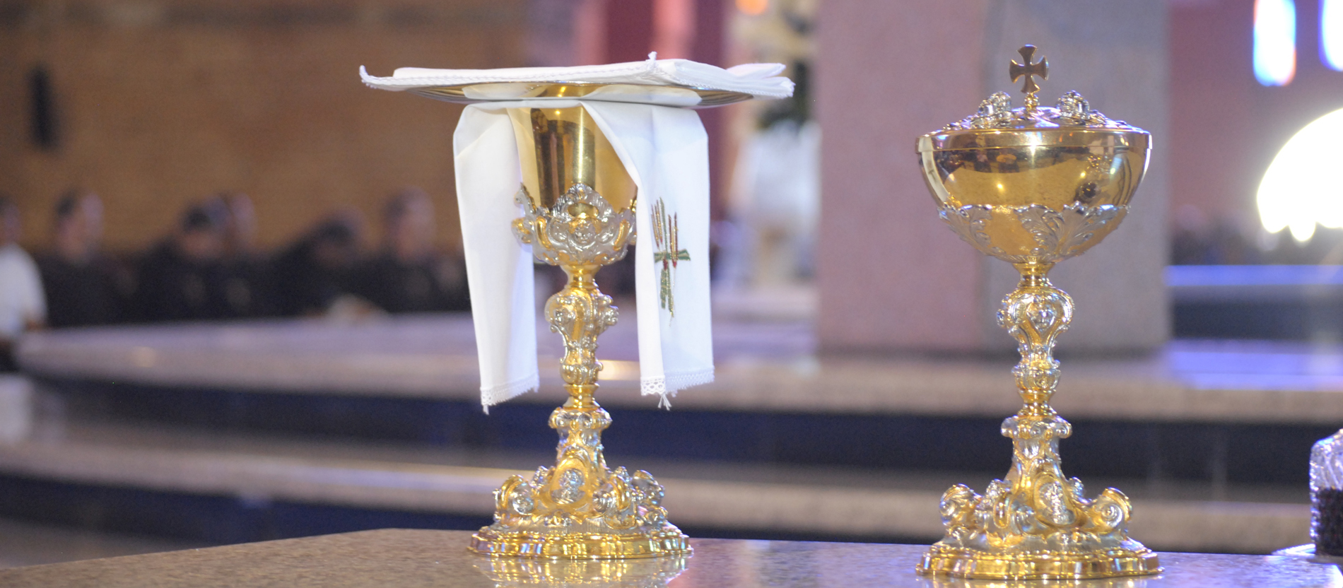 KELCHWÄSCHE: Zum Kelch (links im Bild) gehört das leinene Kelchtuch, mit dem der Priester das Gefäß auswischt. Darauf liegt entweder die Patene oder eine Palla, das ist ein quadratisches Leinentuch, das durch ein eingearbeitetes Stück Pappe verstärkt ist. Die Palla soll Verunreinigungen des Messweins verhindern. Bis zur Gabenbereitung ist der Kelch häufig von einem so genannten Velum verhüllt, ein festlicher Stoff in der liturgischen Farbe des Tages, der den Kelch den Blicken entzieht und zugleich darauf hinweist, dass die Gläubigen hier etwas Besonderes erwartet.