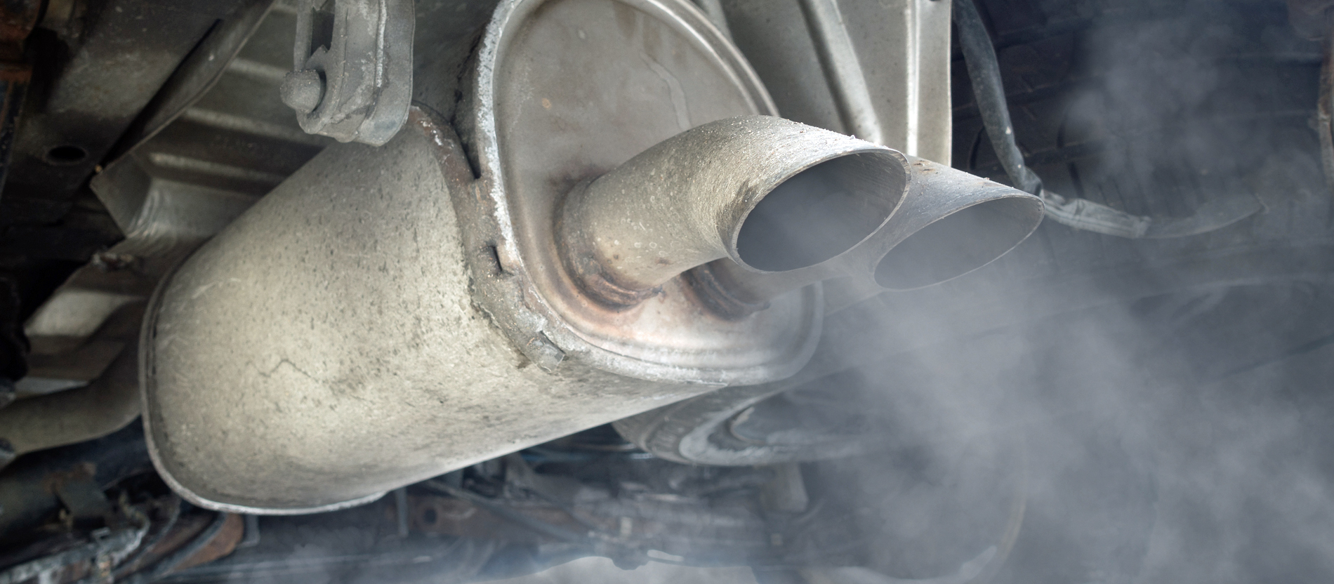 Dreckiger, qualmender Auspuff eines alten Autos