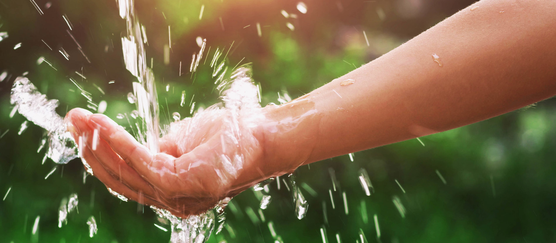 Auf eine Hand fließt Wasser. 