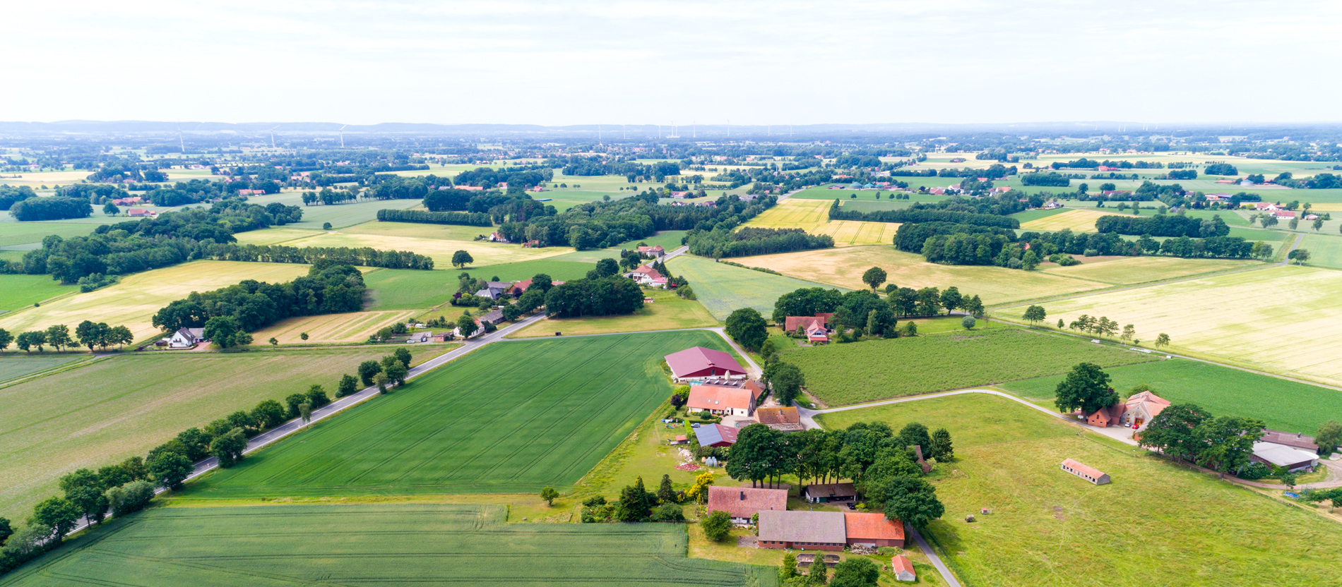 Blick über eine weite Landschaft mit Feldern und Dörfern.