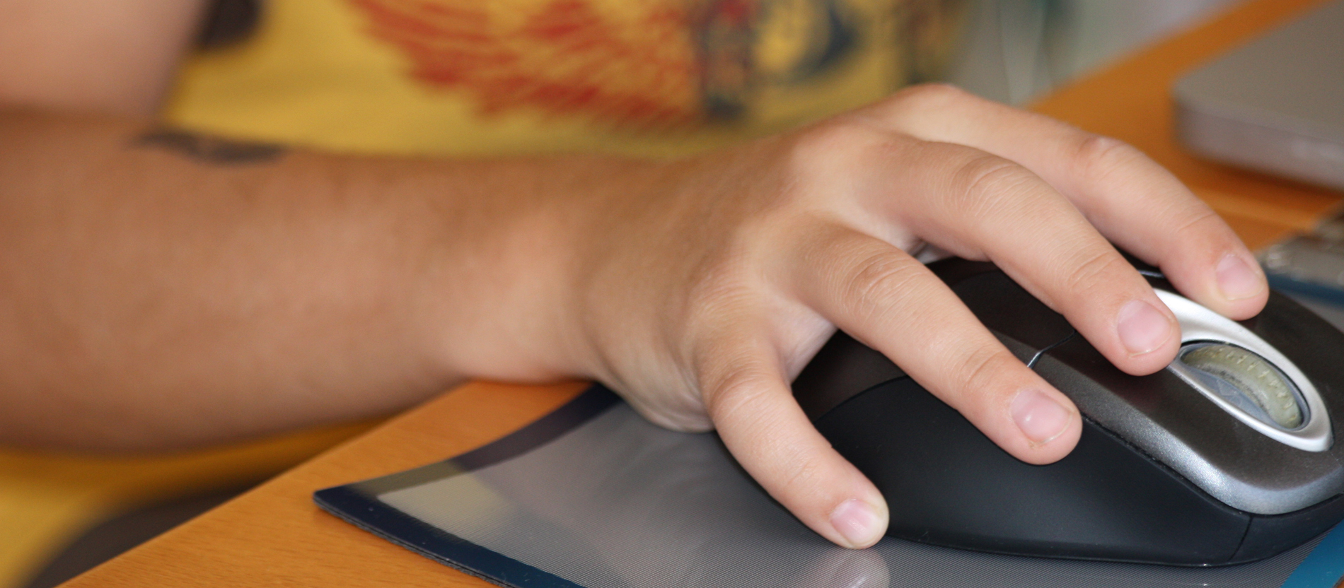 Hand eines Jugendlichen umfasst eine Computermouse