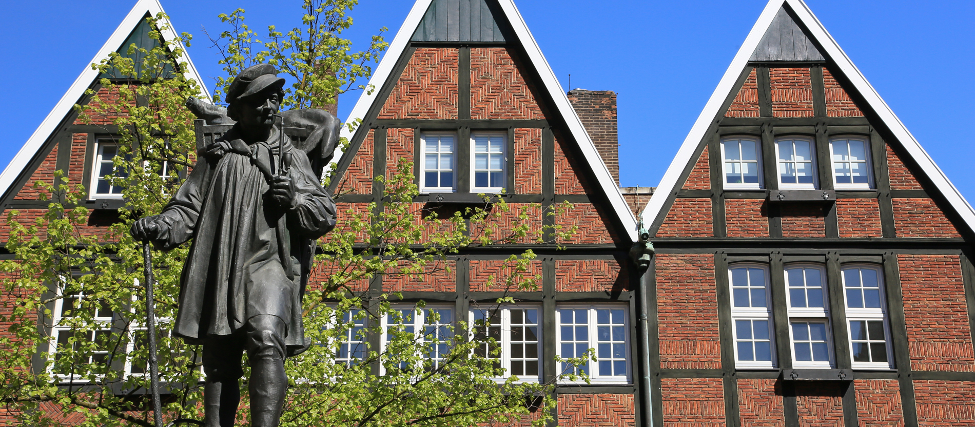 Kiepenkerl vor Giebelhäusern