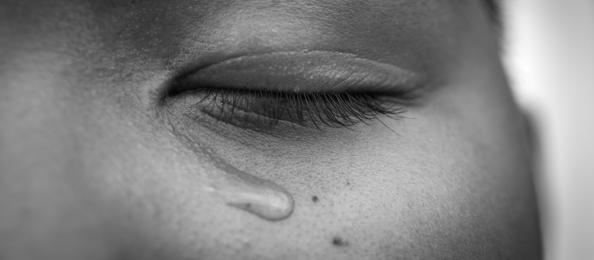 Ein Kind hat die Augen geschlossen und weint.