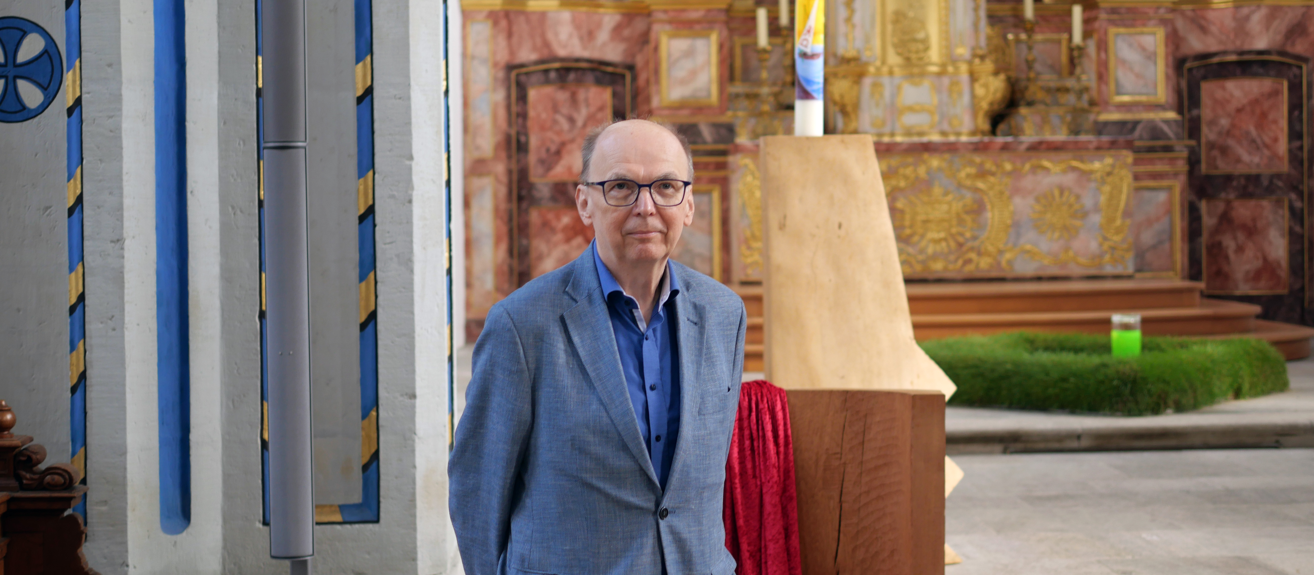 Bischof Matthias Ring steht in Zivil vor dem Altar der Bonner Namen-Jesu-Kirche