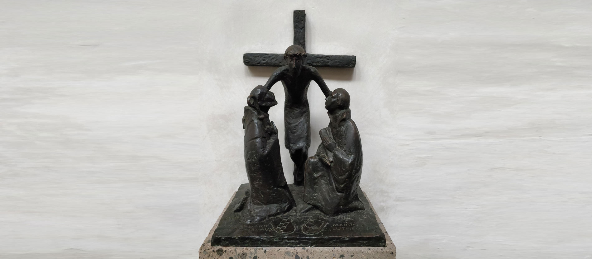 Statue im Altenberger Dom: Christus umarmt Martin Luther und Bernhard von Clairvaux