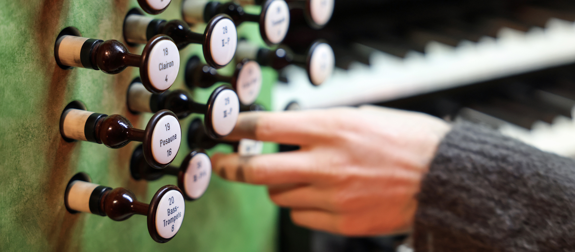 Hand an den Registern einer Orgel