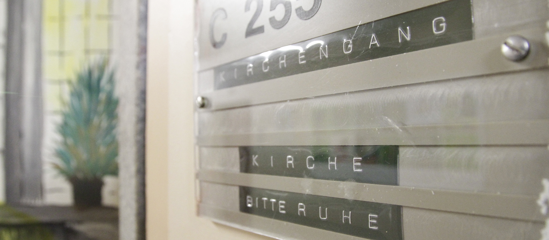 Auf dem Türschild zur Gefängniseelsorge steht: Kirchengang, Kirche, Bitte Ruhe