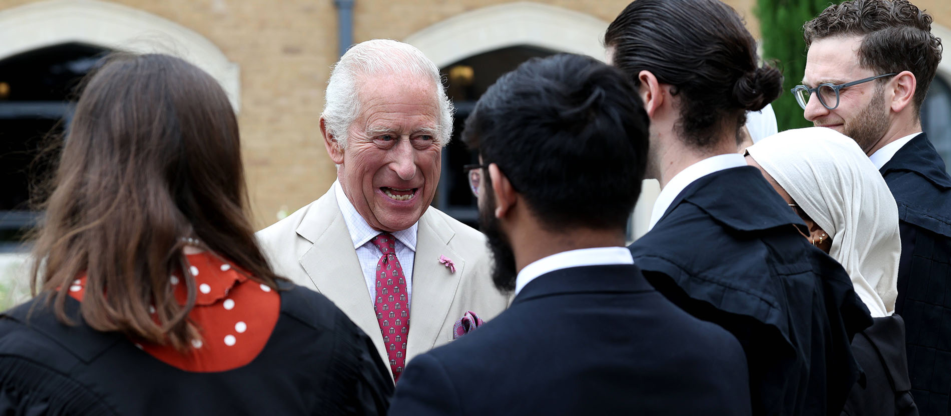 König Charles III. trifft Menschen und lacht