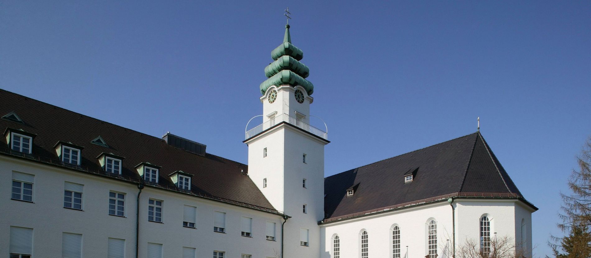 Das Studienseminar Sankt Michael in Traunstein mit weißen Gebäuden und Turm.