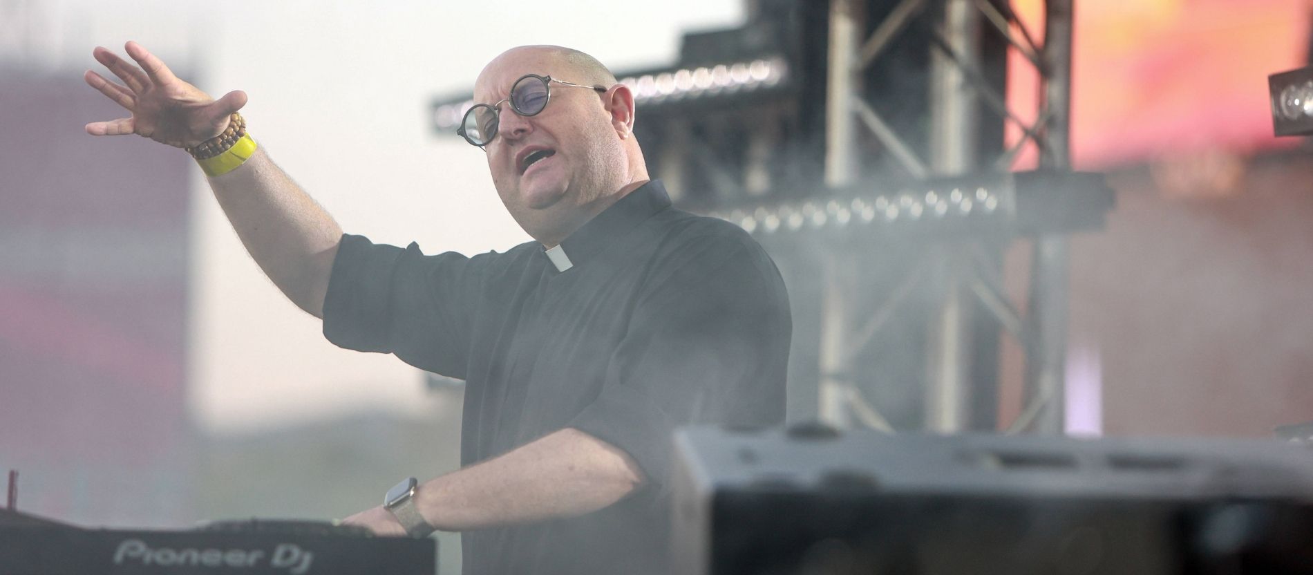 Der Priester und DJ Padre Guilherme steht mit geschlossenen Augen an einem DJ-Pult