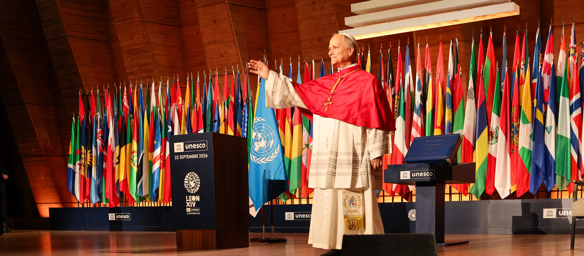Papst Leo steht auf einer Bühne der UNESCO. Hinter ihm stehen die Flaggen aller Mitgliedsstaaten