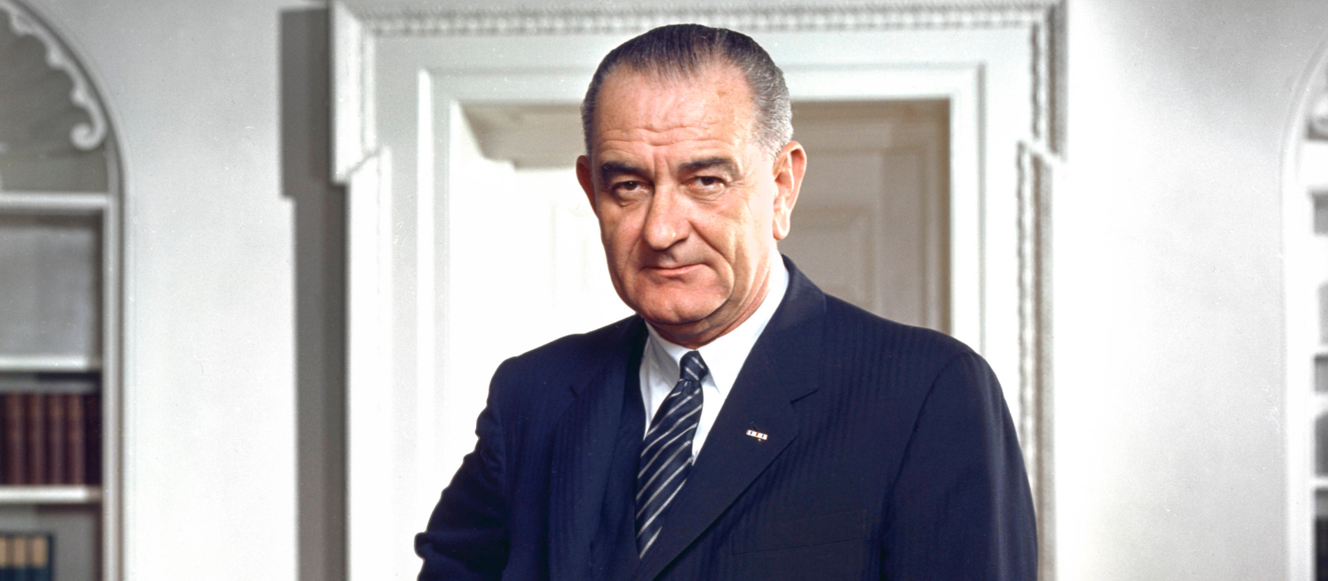 US-Präsident Lyndon B. Johnson blickt direkt in die Kamera. Er trägt einen Anzug.