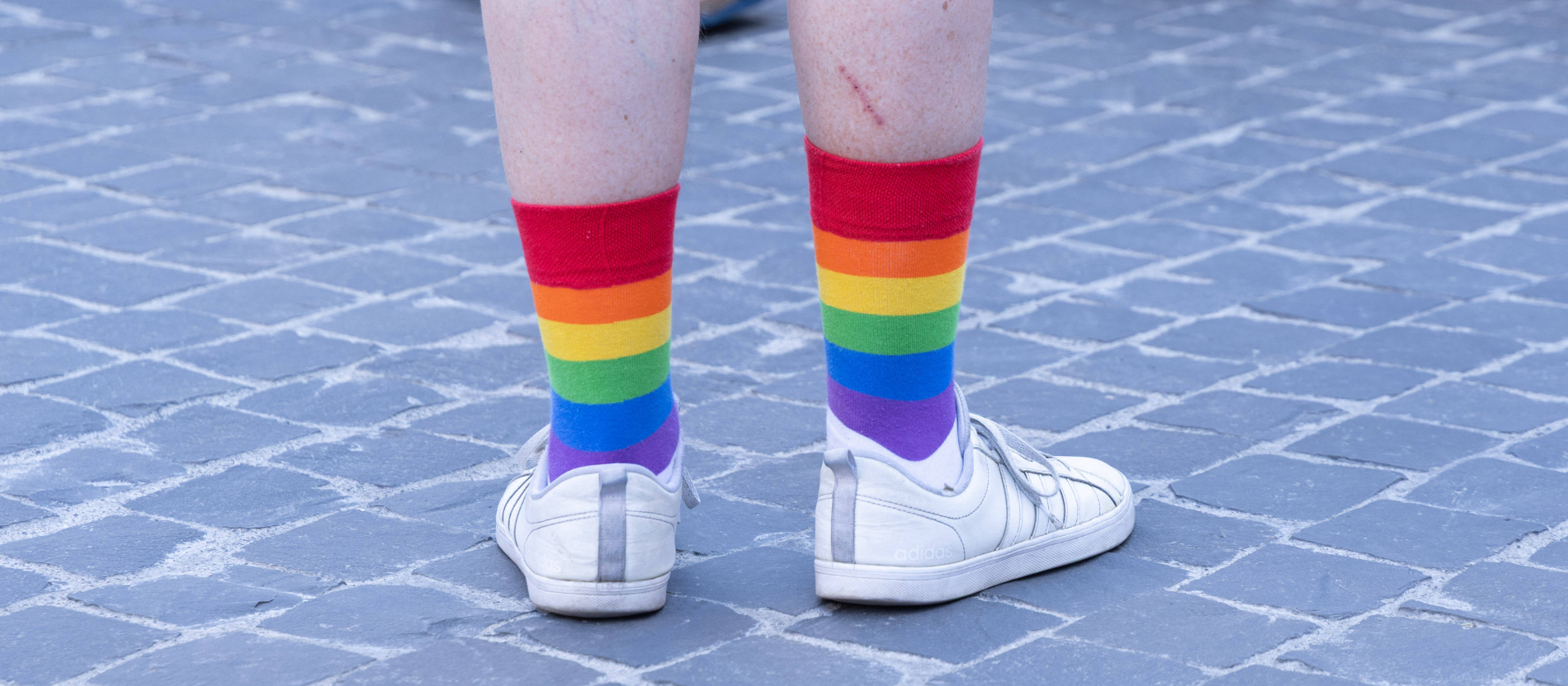 Ein Mensch trägt Regenbogensocken