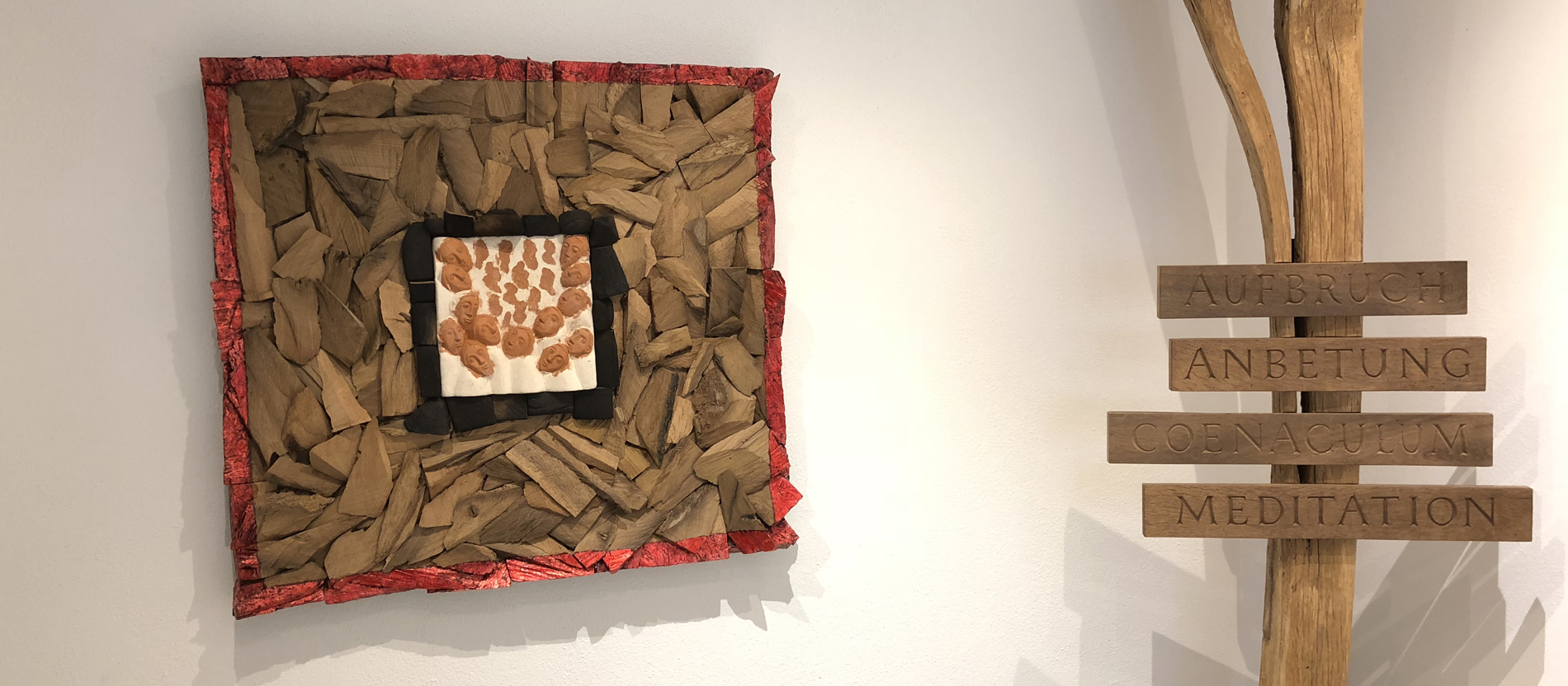 Kunstwerke aus Holz. Auf einem stehen die Worte Aufbruch, Anbetung, Coenaculum und Meditation.