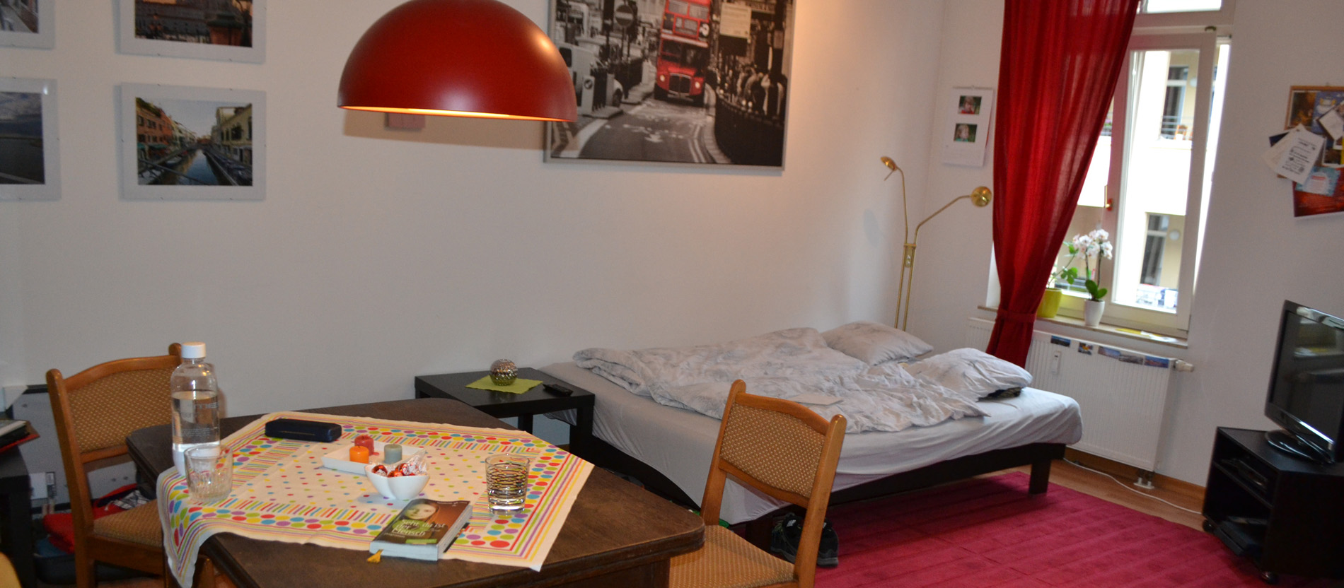 Ein Zimmer mit einem Esstisch und einem Bett.