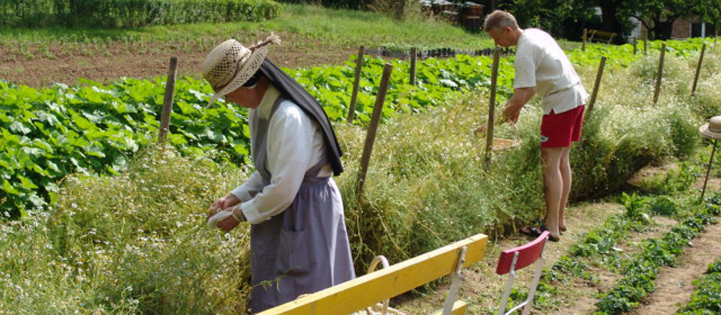 Eine Nonne und ein Besucher arbeiten im Kräutergarten des Klosters Arenberg.