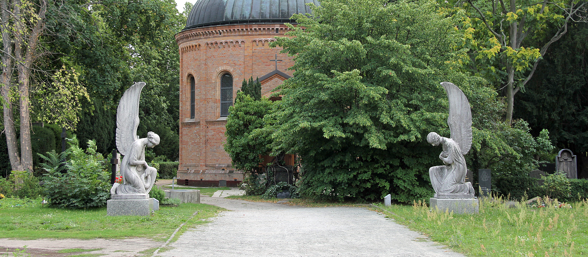 Direkt neben dem evangelischen Domfriedhof liegt der katholische Domfriedhof. An seinem Eingang begrüßen zwei knieende Engel des Bildhauers Josef Limburg die Besucher.