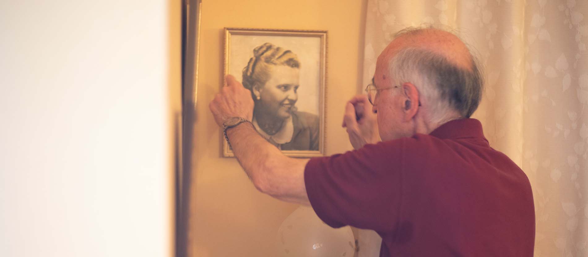Hubert Rieck hängt ein Bild auf