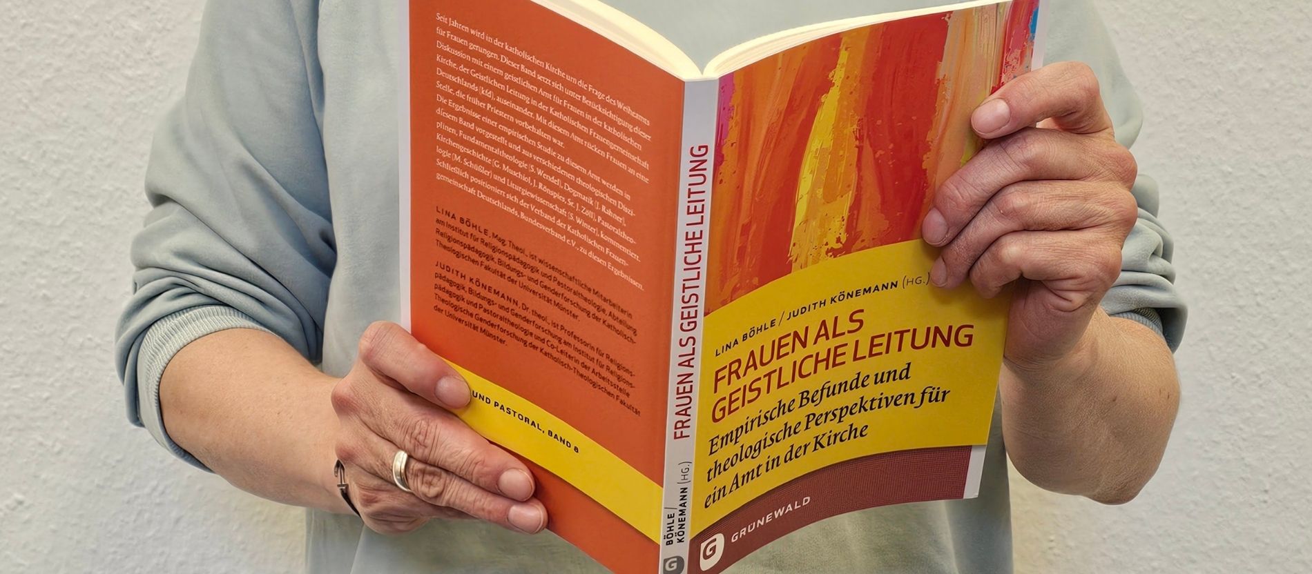 Eine Frau hält das Buch "Frauen als Geistliche Leitung" in den Händen