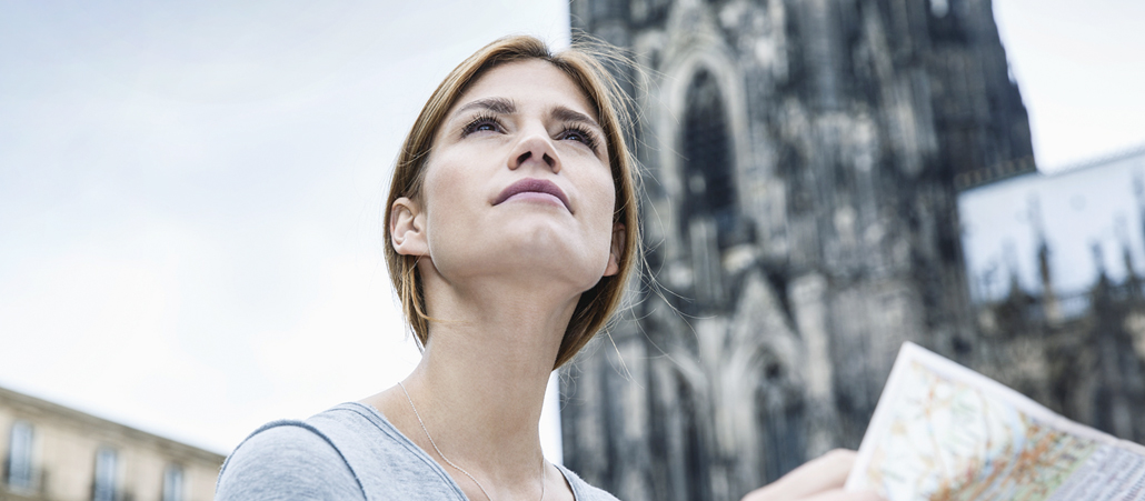 Junge Frau mit Stadtplan vor dem Kölner Dom