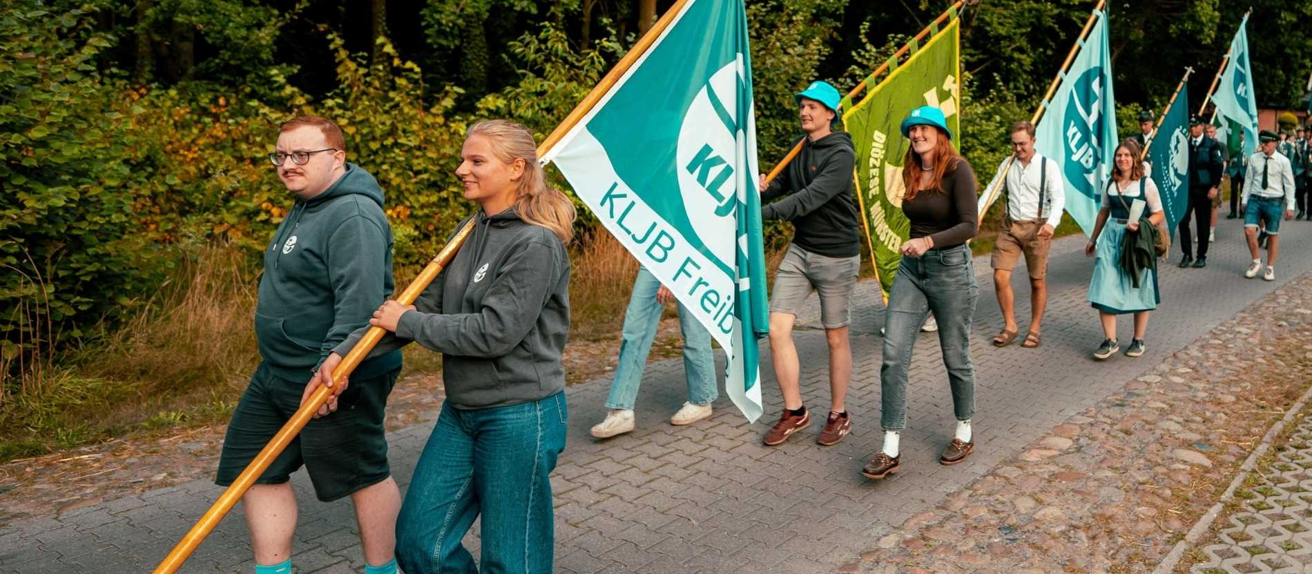 Mitglieder der KLJB tragen Fahnen ihrer regionalen Gruppen.