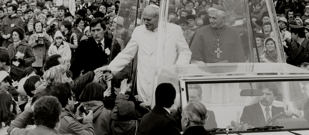 Joseph Ratzinger gilt als enger Vertrauter des polnischen Papstes Johannes Paul II. (links). Bereits als Erzbischof empfängt er Karol Wojtyla in München, der ihn wenig später an die römische Kurie beruft. 
Die unterschiedlichen Stile des medienerfahrenen, volksnahen Papstes und des stillen, intellektuellen Theologen ergänzen sich gut. Hinzu kommt, dass beide eine ähnliche theologische Grundhaltung prägt. Mehrere Rücktrittsgesuche Ratzingers, zuletzt zu seinem 75. Geburtstag, lehnt der polnische Papst allerdings ab.
Er kann und will auf Ratzinger an seiner Seite nicht verzichten. Als Dekan des Kardinalkollegiums leitet Ratzinger 2005 die Beisetzungsfeierlichkeiten nach dem Tod von Johannes Paul II.
