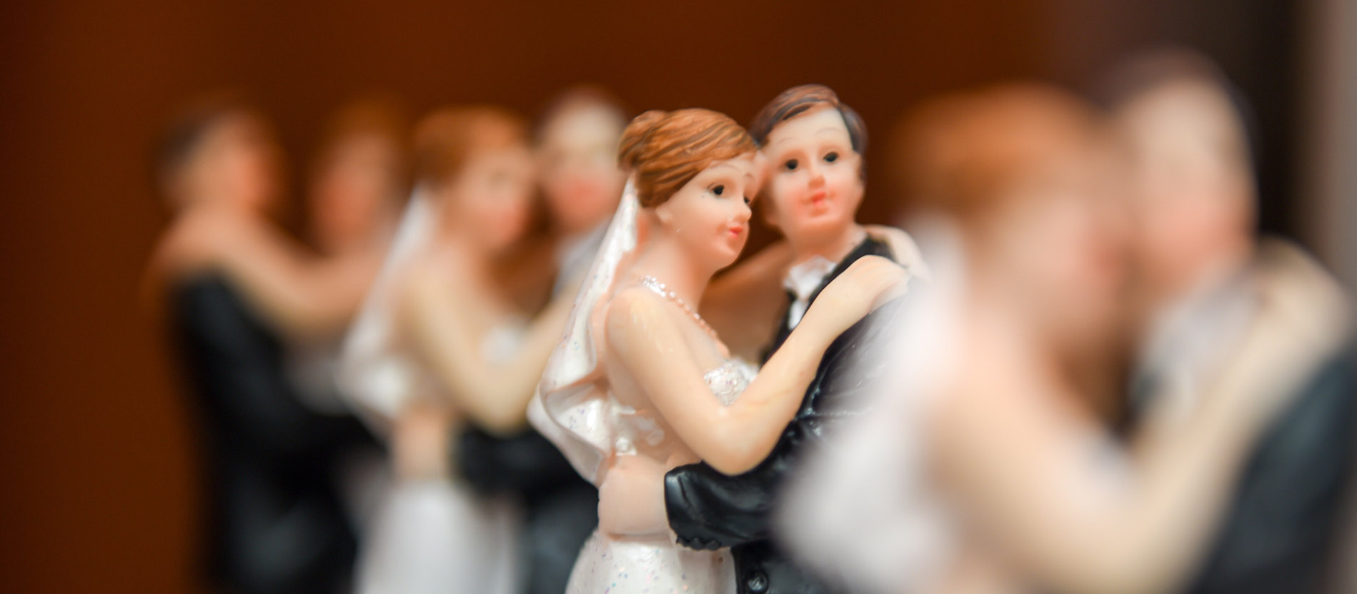 Eine Figur eines Brautpaares auf einer Hochzeitstorte. 