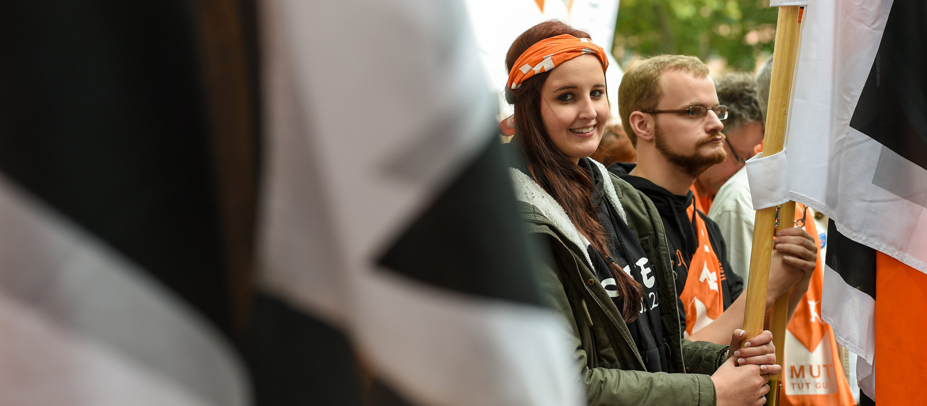 Eine junge Teilnehmerin des Kolpingtags 2015 hält eine Kolping-Fahne.