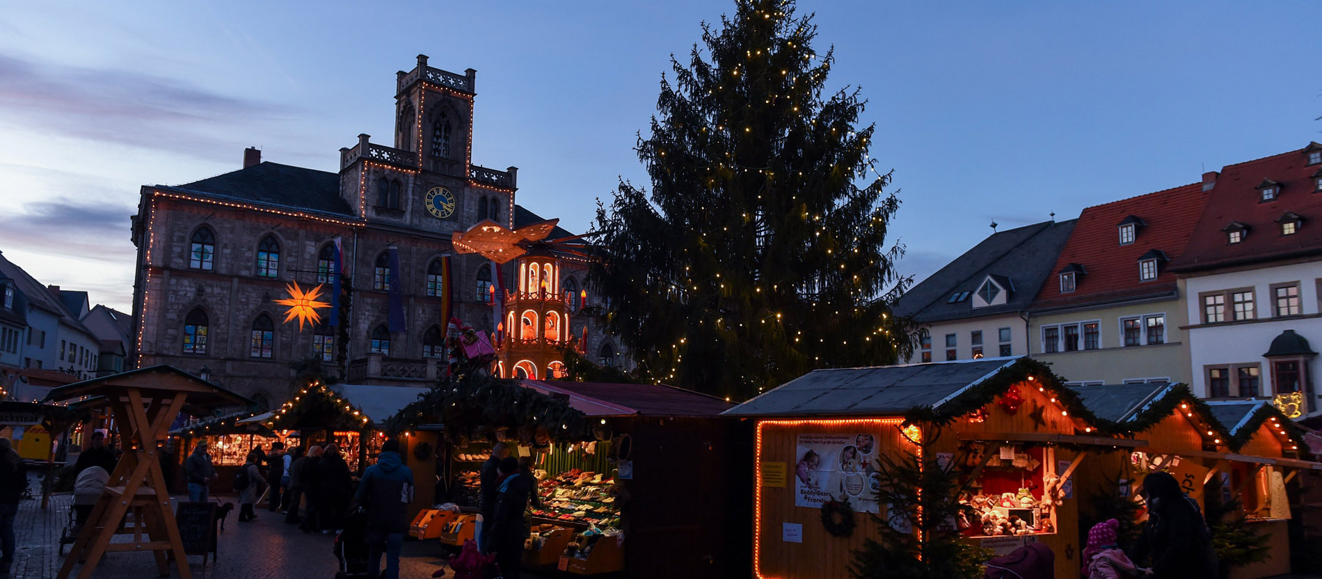 Auf einem Weihnachtsmarkt steht ein Christbaum.