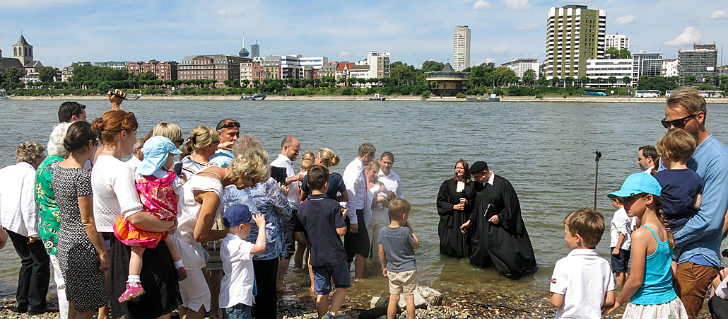 Die evangelische Pfarrerin Anna Quaas und der evangelische Pfarrer Mathias Bonhoeffer taufen im Rhein.