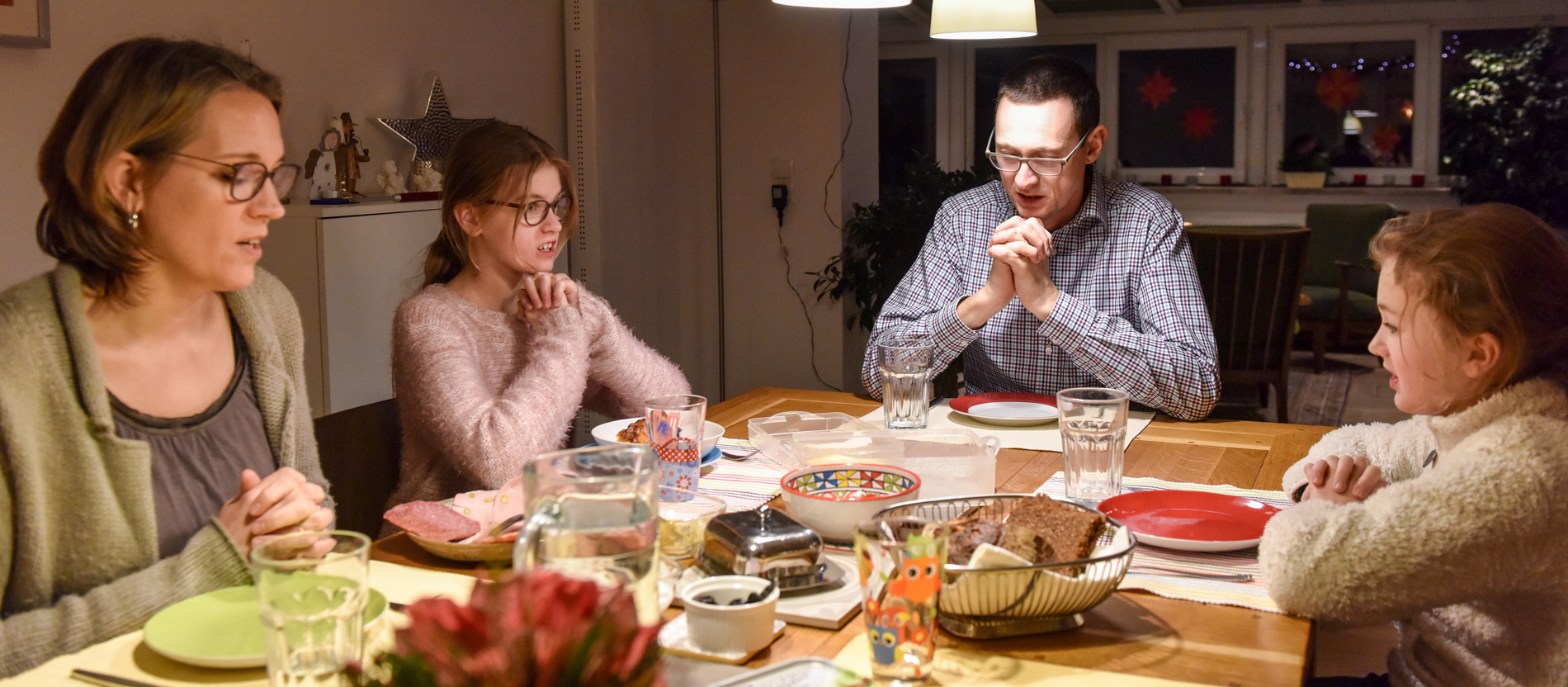 Eine Familie beim Abendessen betet