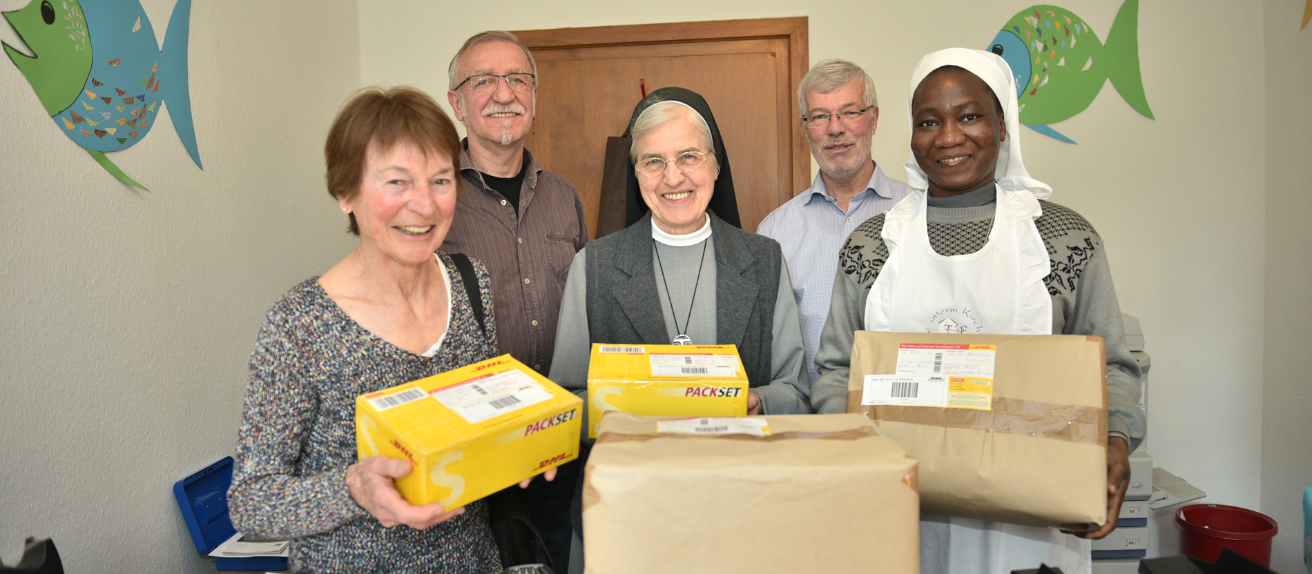Eine Gemeinde in Kiel hat einen Paketshop eröffnet. Die Ehrenamtlichen halten Pakete