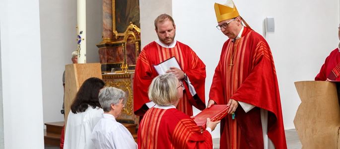 Bischof Matthias Ring übergibt einer Diakonin das Evangeliar während des Gottesdienstes zu ihrer Weihe zu alt-katholischen Diakoninnen.