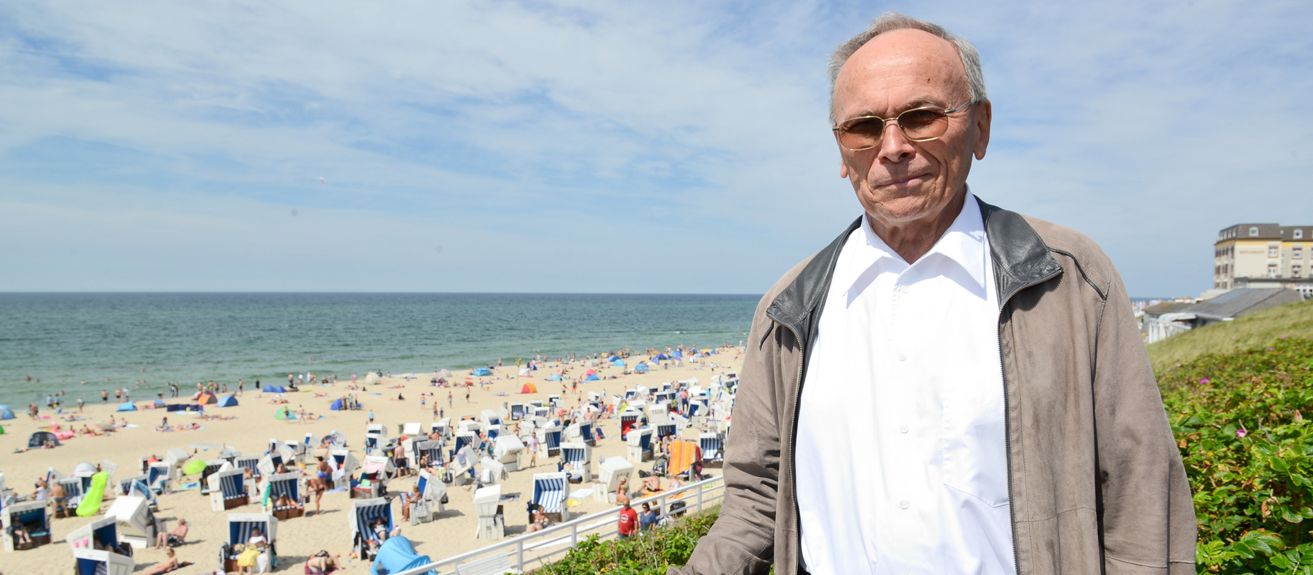 Ein älterer Herr steht am Strand auf Sylt