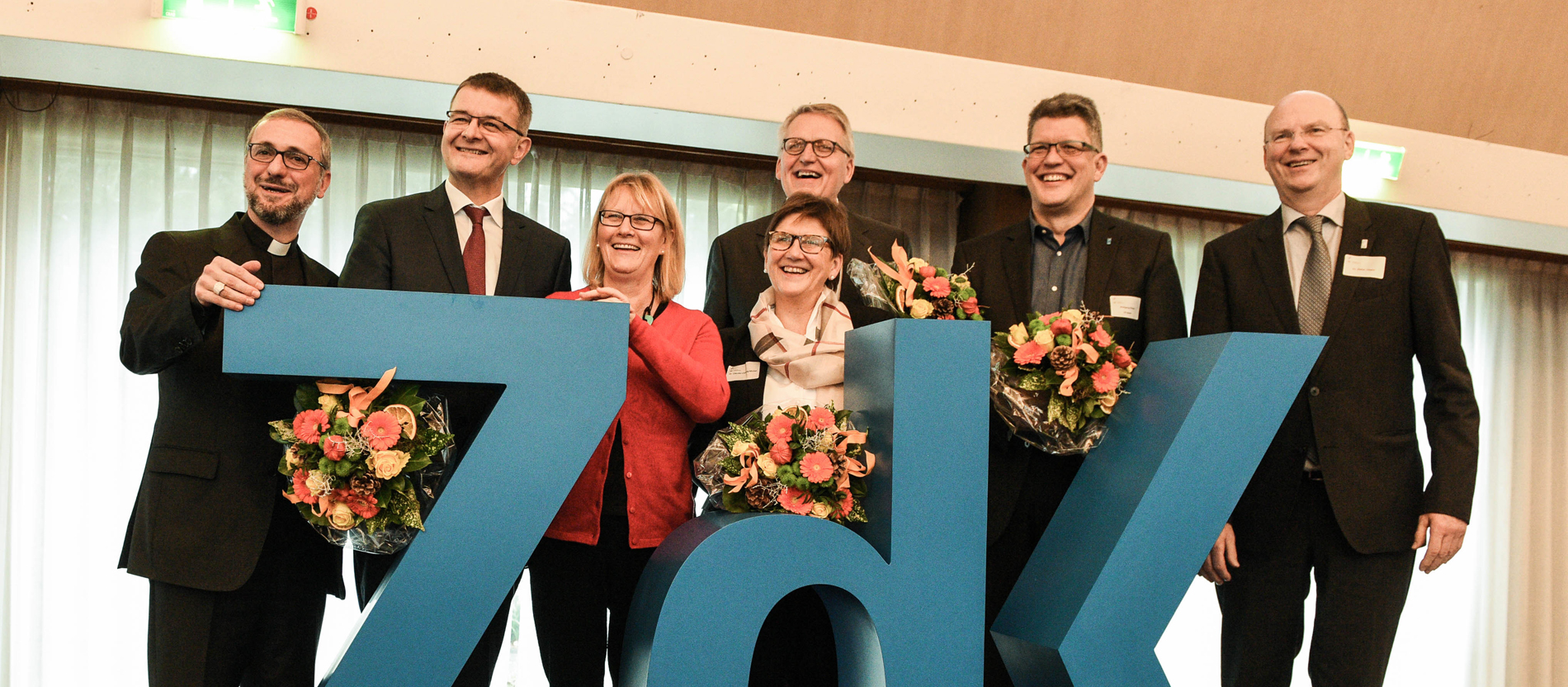 Das Präsidium des ZdK steht hinter dem Logo der Organisation für ein Gruppenbild.