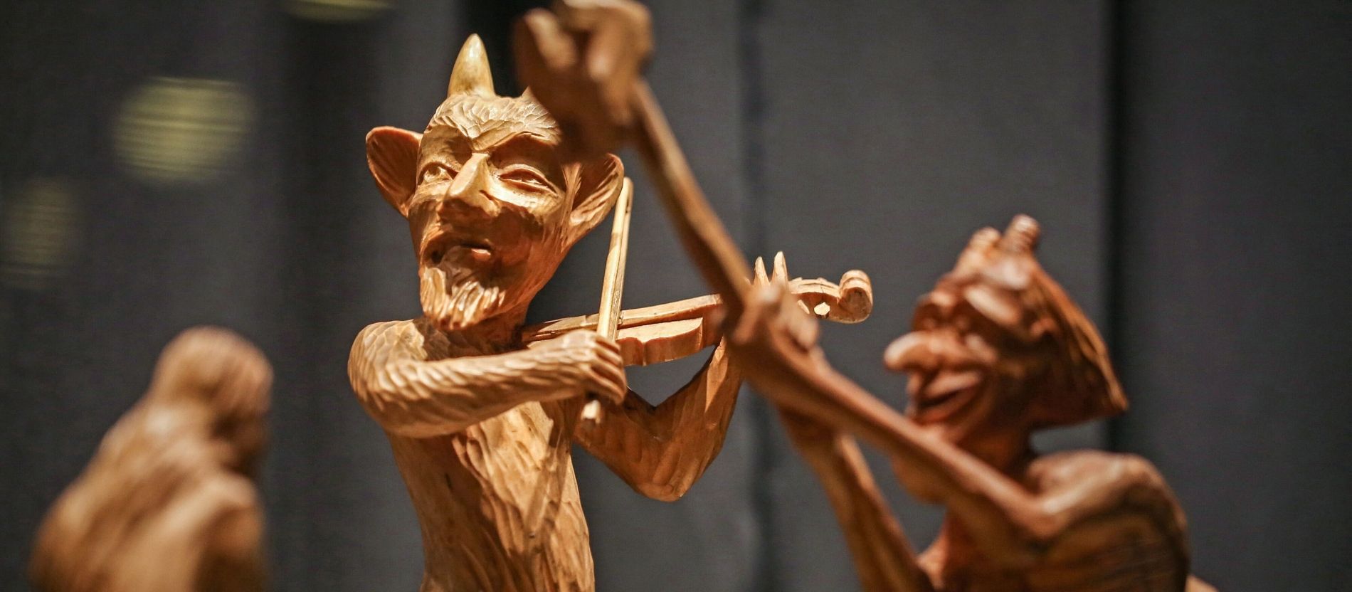 Aus Holz geschnitzte Teufelsfigur, die Geige spielt