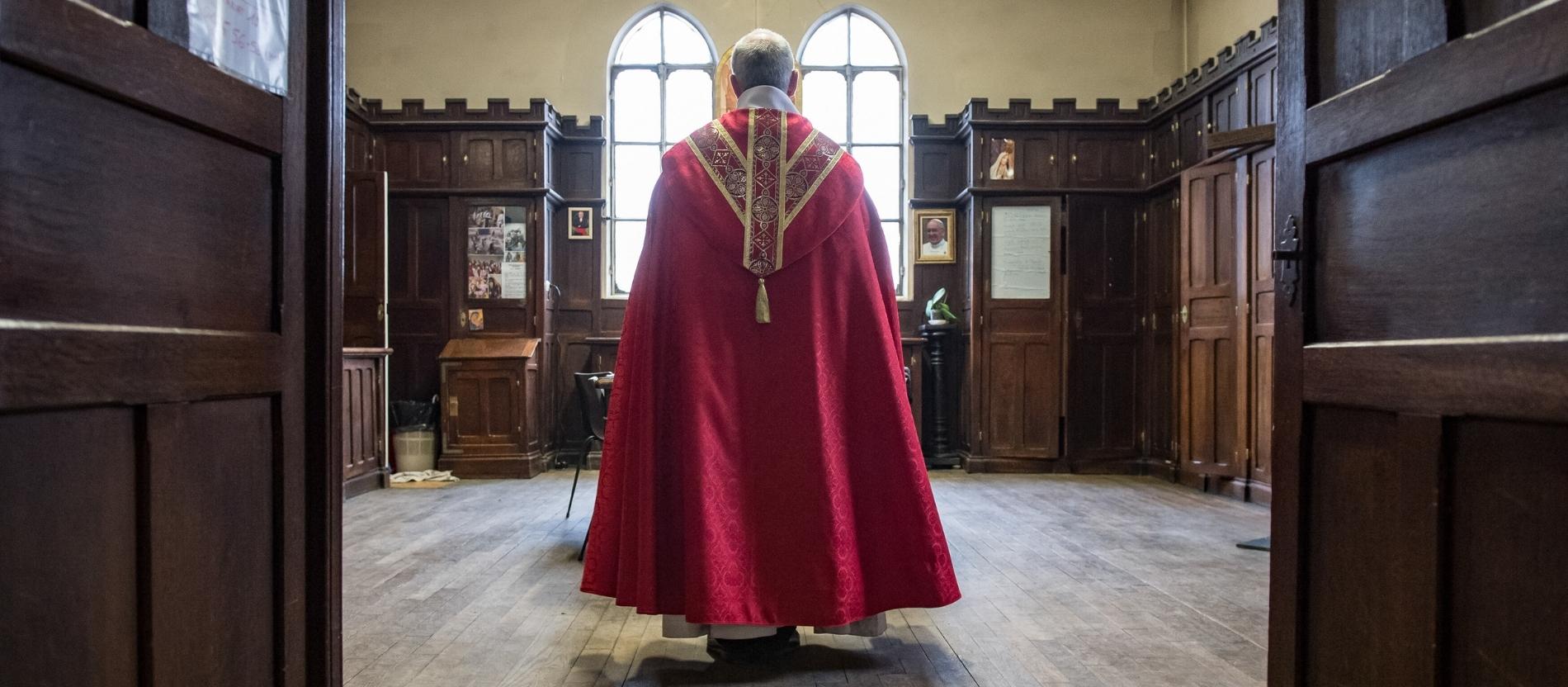 Rückansicht eines Priesters in einer Sakristei